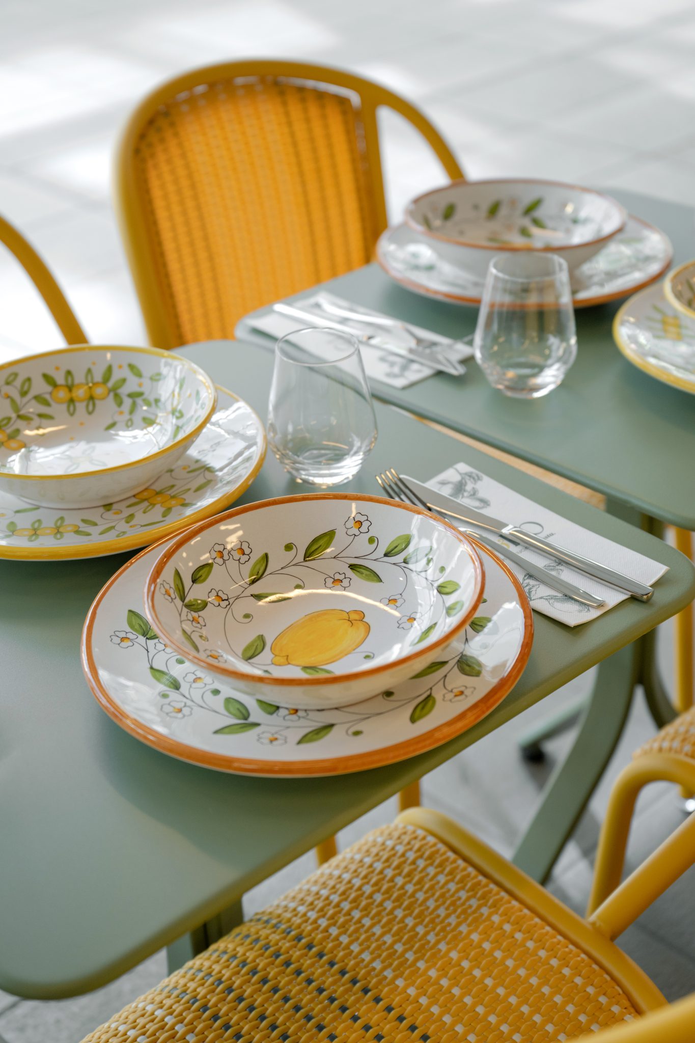 Table avec vaisselle colorée et chaises jaunes